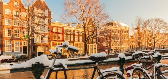 Bicycles covered with snow during winter in Amsterdam © Martin Bergsma - stock.adobe.com