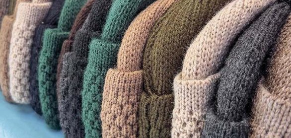 row of colorful knitted hats on shelf in store © berna_namoglu - stock.adobe.com